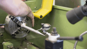 Close up of a metal component in the chuck of a lathe in the Marble workshop