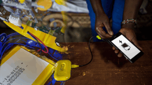 Composite photo showing someone charging their phone from the Sunlight battery power pack. Overlayed with an image showing the internal electronics and battery of the power pack