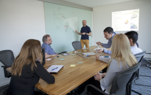 Marble team brainstorming ideas around a table covered with product samples